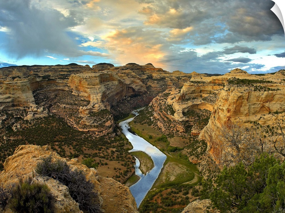 High angle photograph of river flowing through canyon under a cloudy sky.
