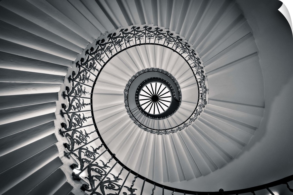 Photograph looking up at a spiral staircase.