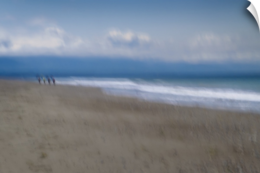Blurred motion image of a couple walking along the shore.