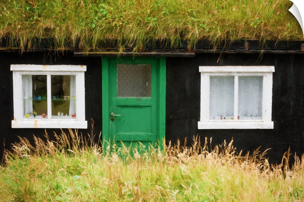 A rural house with a thatched roof and a green door.