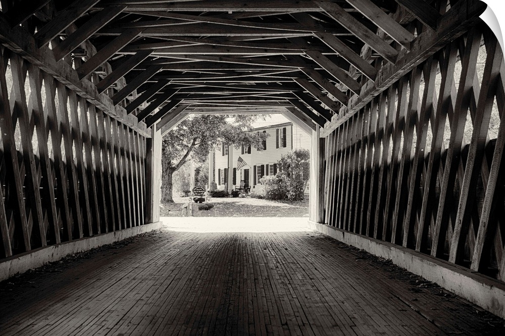 Fine art photo of the inside of a wooden covered bridge, in black and white.