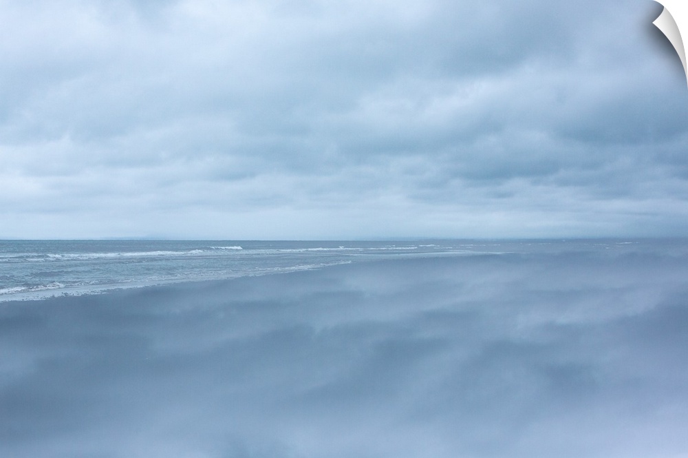 Dense clouds over the ocean before a storm, in pale blue light.
