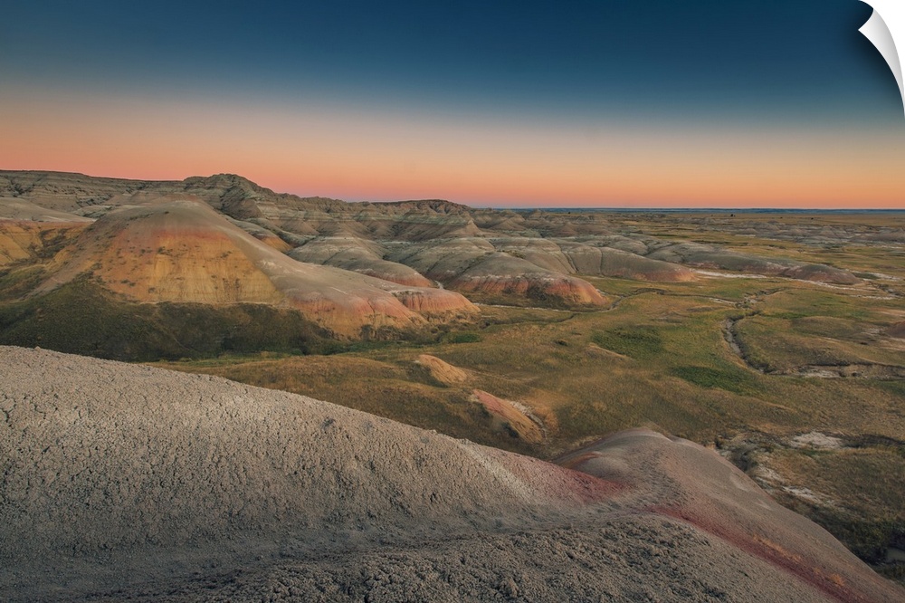 Sunset over layered rock formation in Badlands National Park, South Dakota.