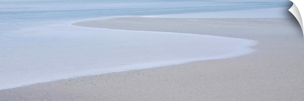 A photograph of a long beach on a hazy day.