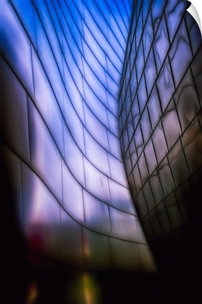 A Vertical photograph of architectural detail of Reflective Metal Plates in Soft Blue Light.