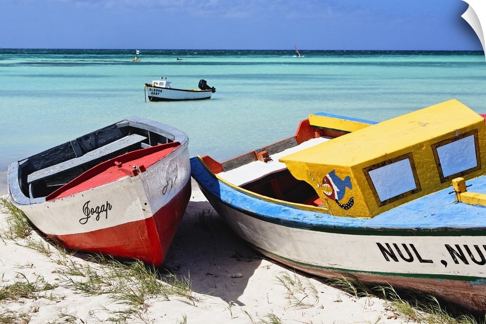 A photograph of colorful boats sitting on the shore of a tropical beach.
