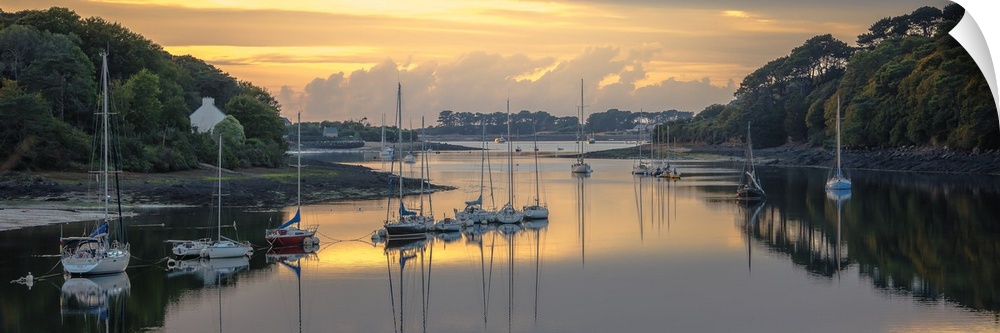 Sailboats in the harbor of the Wrac'h river in a small fishing village in France at sunset.