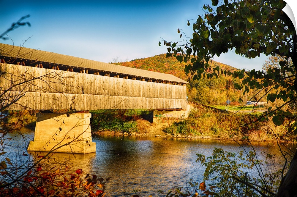 A covered bridge over the river in late afternoon sunlight, New Jersey.