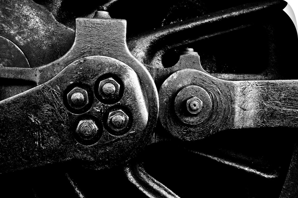 A close up in monochrome black and white of a steam engine main crank wheel.