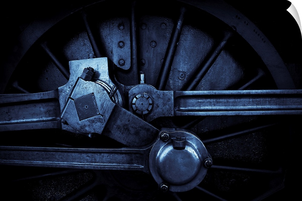 A close up in blue tone of a steam engine main crank wheel.