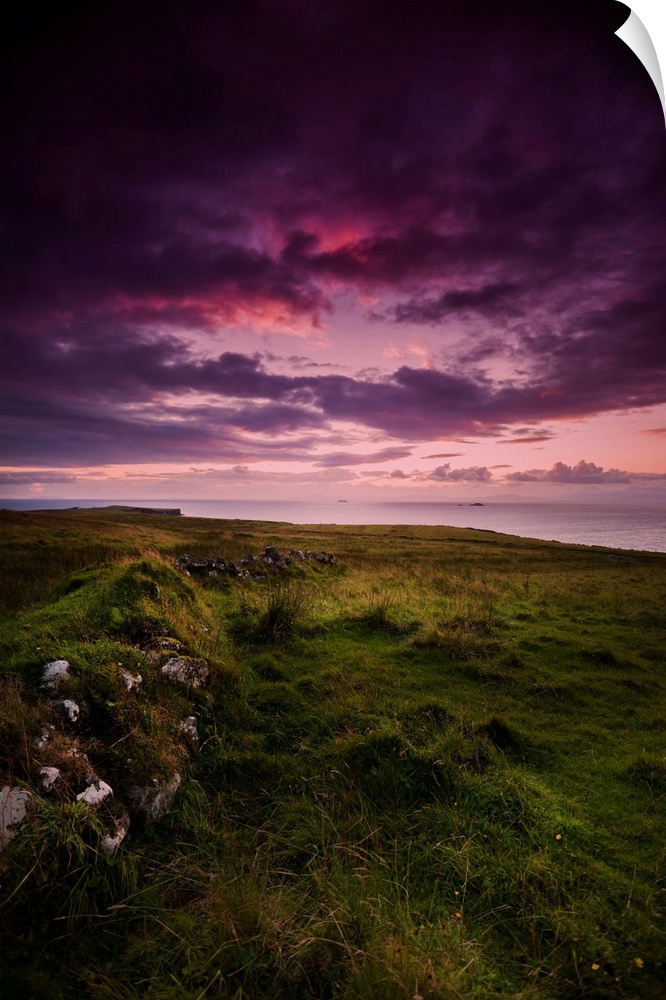 Fine art photo of a dramatic purple sky at sunset over a grassy meadow.