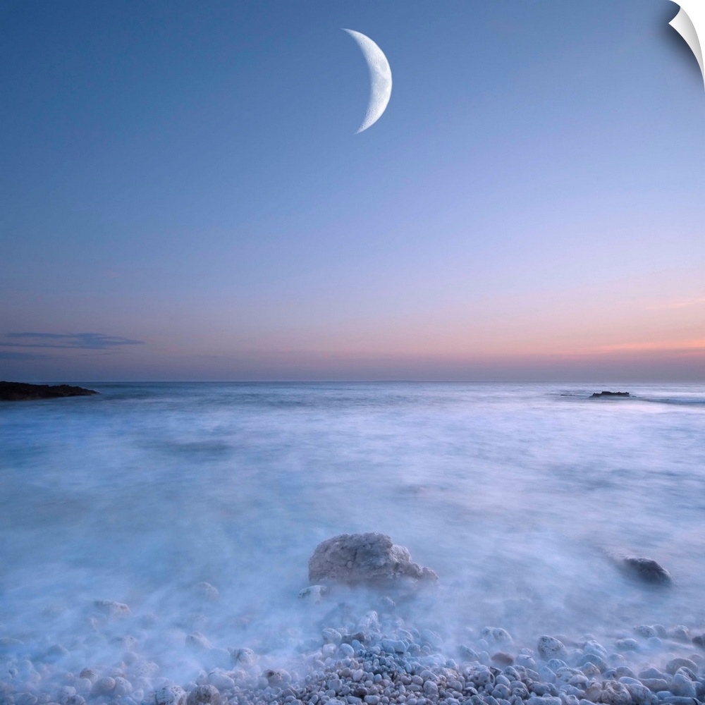 This large art piece highlights a crescent moon with fog cascading over the rocks and water below.