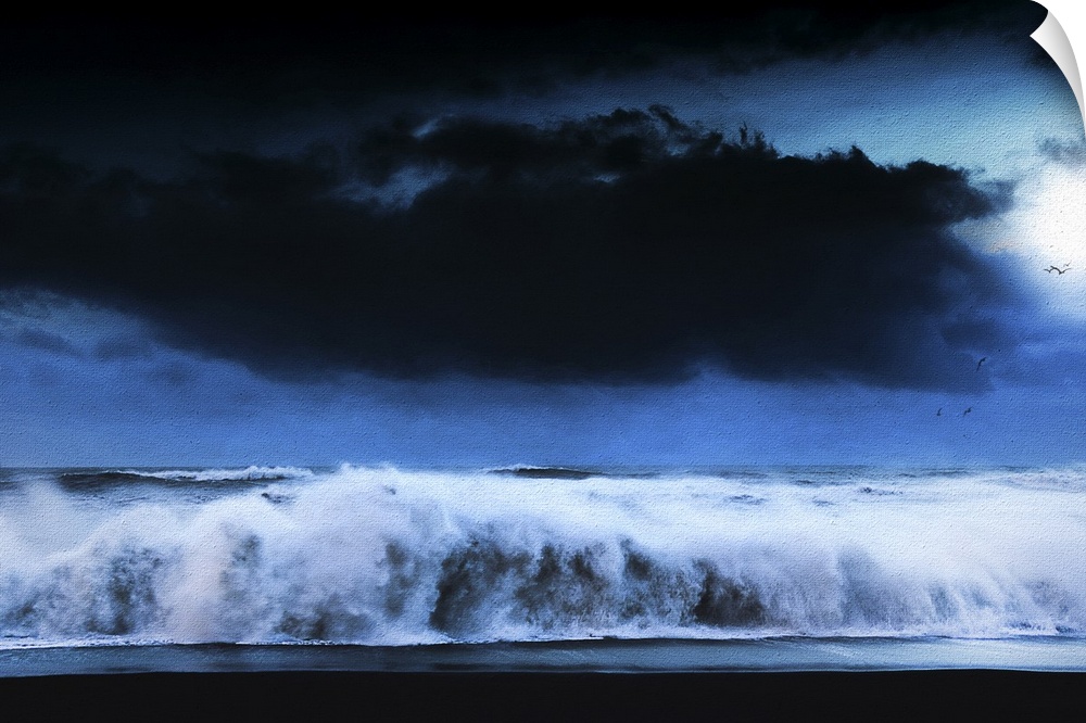 A photograph of a seascape under a dark cloudy sky.