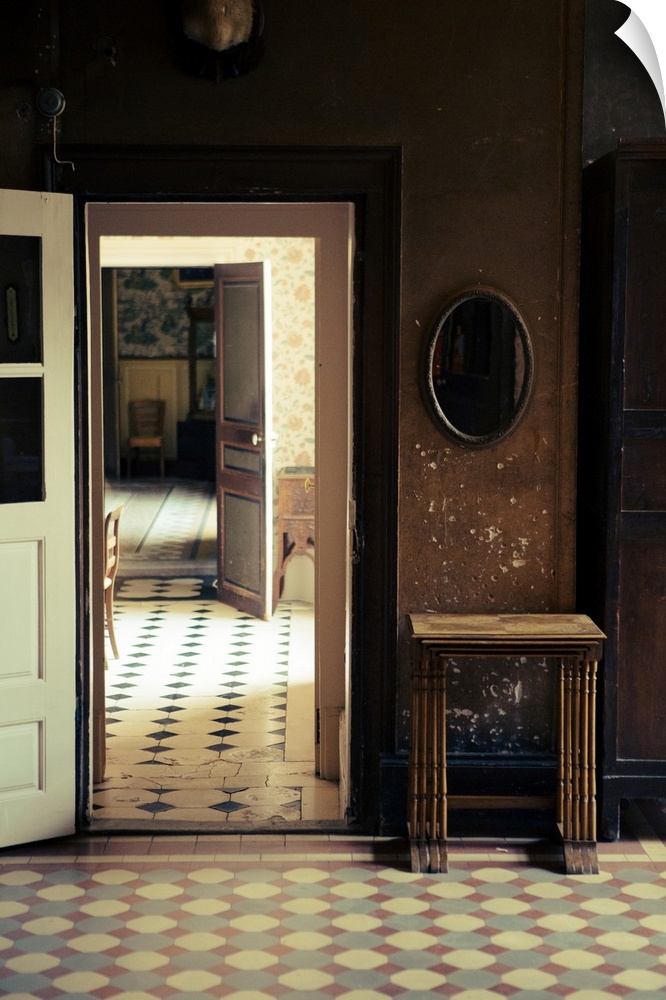 Photograph of an abandoned interior with open doors leading to other rooms with more open doors.