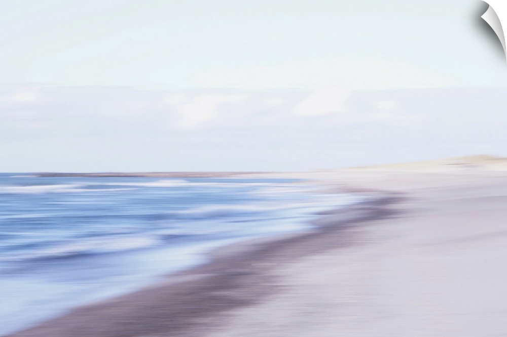 Artistically blurred photo. The waves find a place to rest on the North Sea beach of North Jutland, Denmark, in summer.