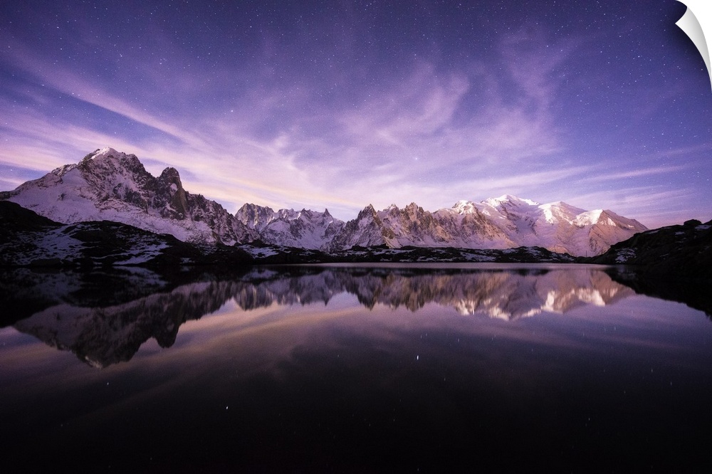A photograph of the French Alps under a purple sky at dusk.
