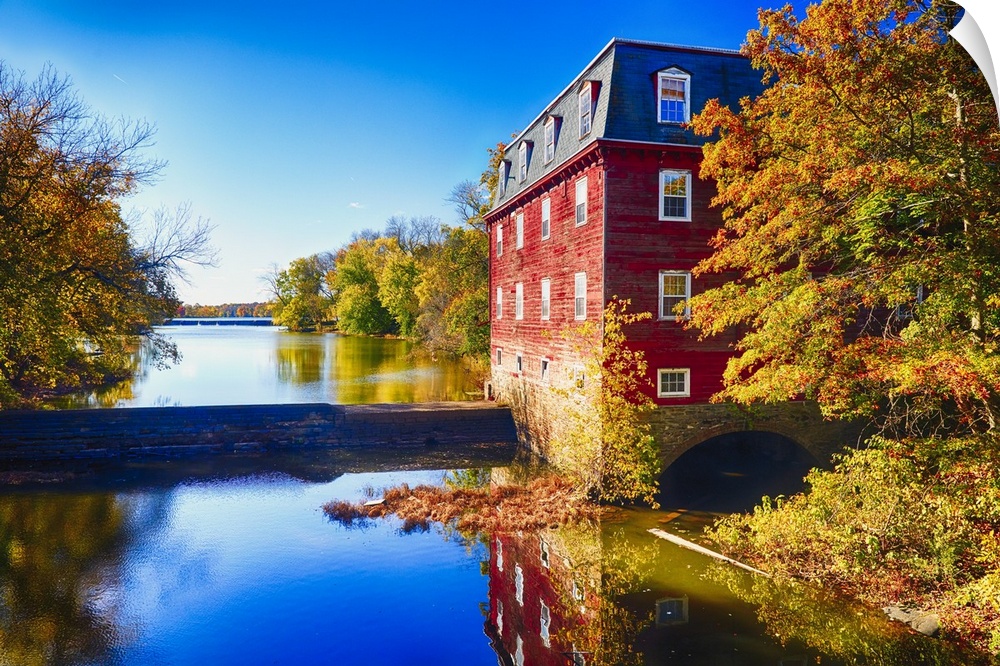 Red grist mill at the edge of the water at Lake Carnegie, New Jersey, in the fall.