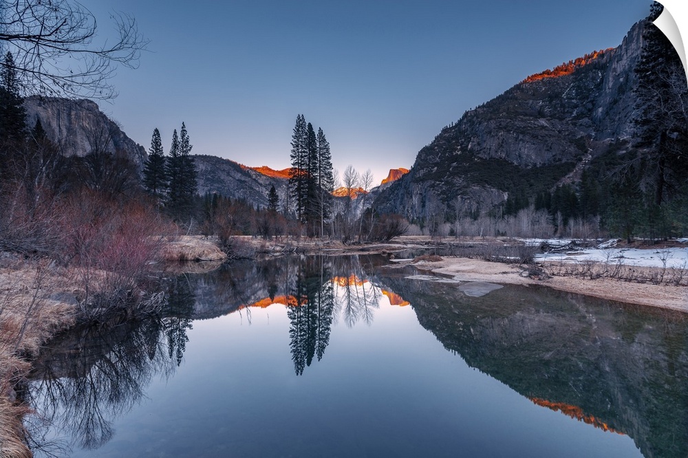 Half Dome and its reflection in Merced River, Yosemite National Park, during golden hour of a sunset.