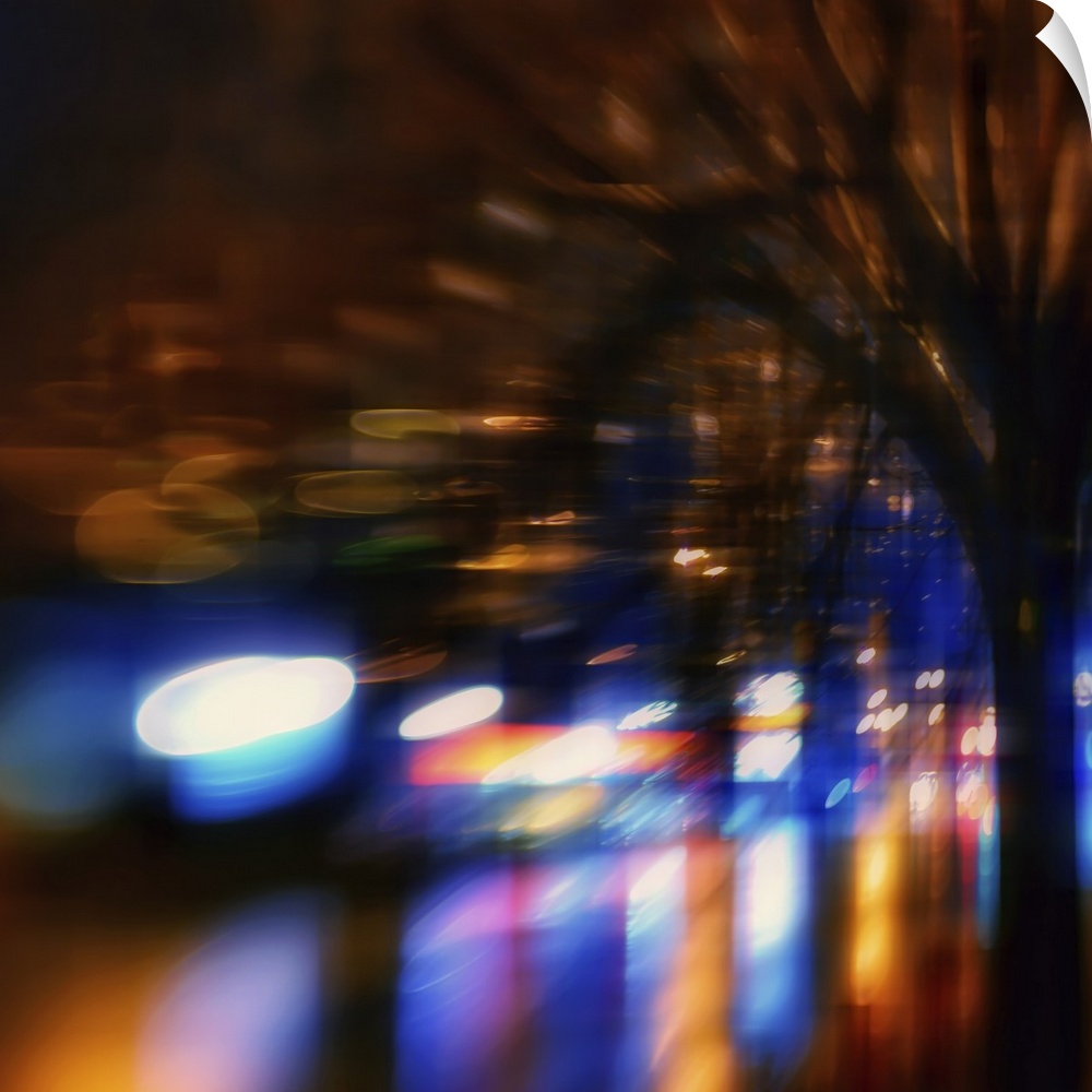 Lights from shops and cars in an urban environment at night, warped and blurred to create an abstract image.