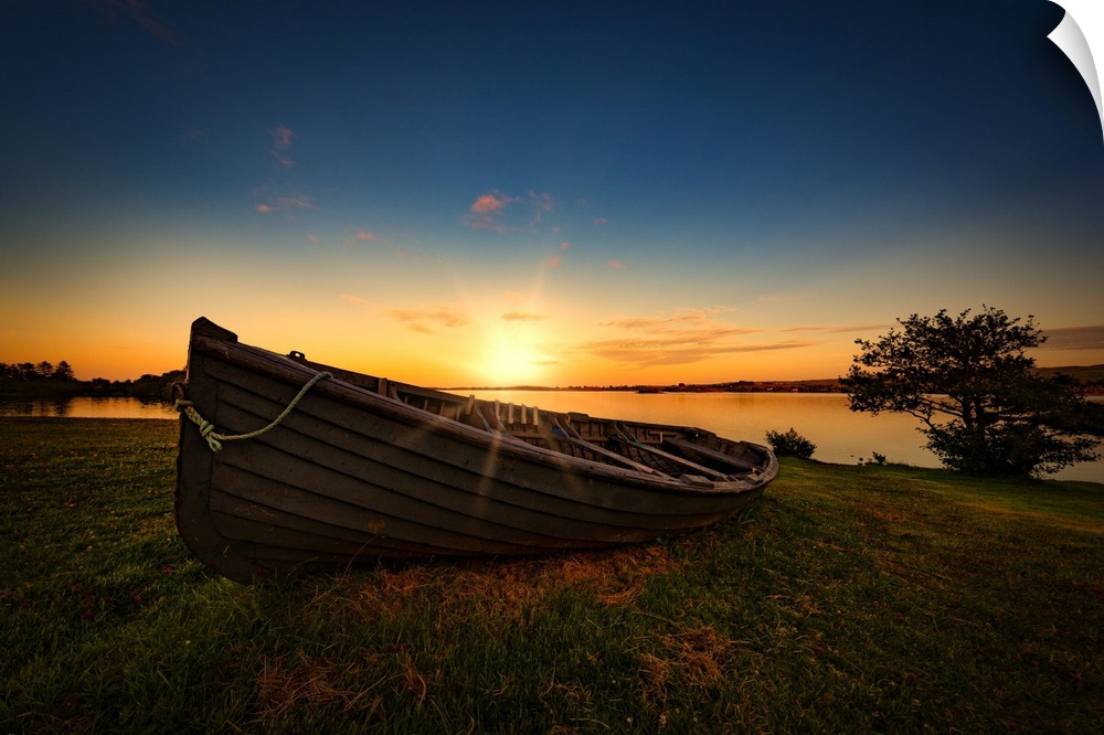 A rowboat by the sea at sunset