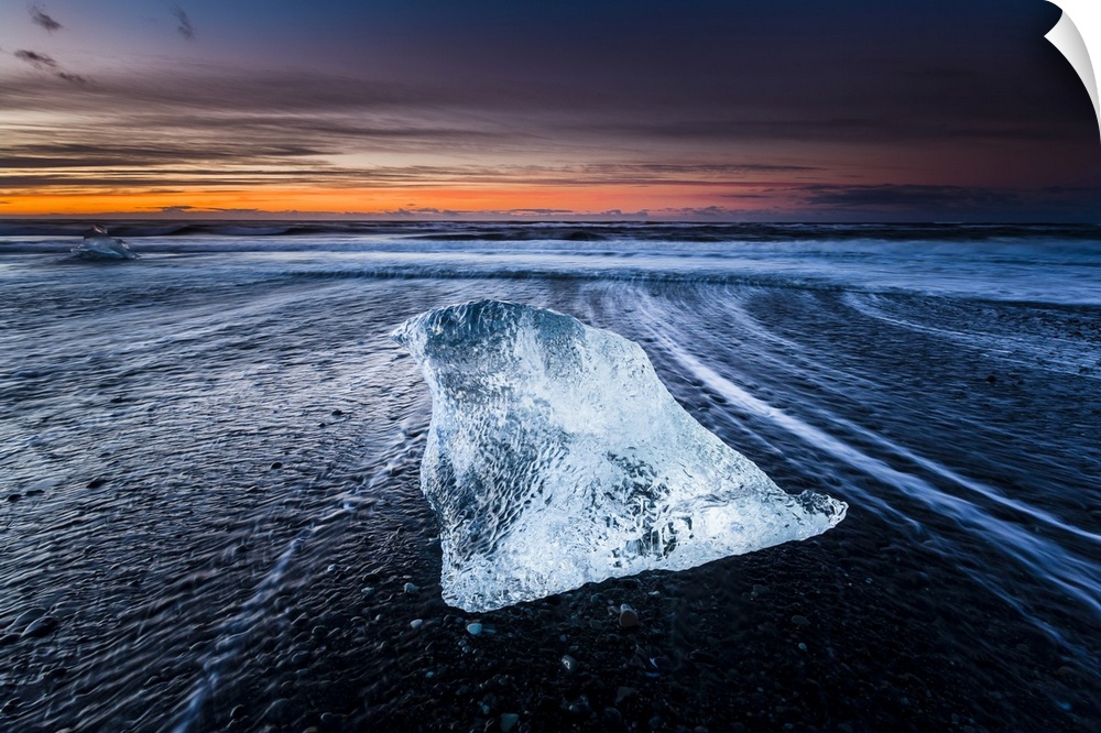 An iceberg laying on the beach near Jokulsarlon, Iceland, captured during sunrise.
