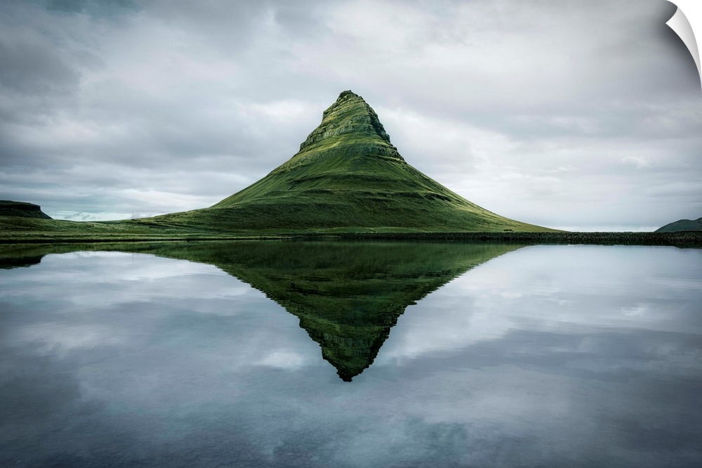 Fine art photograph of the tall peak of Kirkjufell overlooking a calm lake in Iceland.