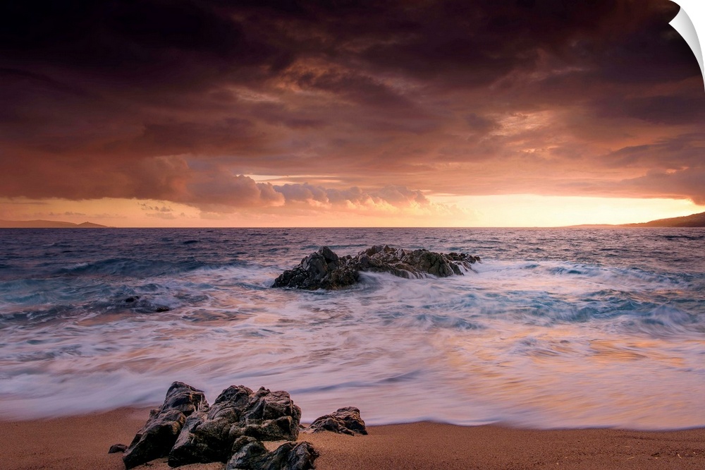A photograph of a rocky sunset coastal landscape.