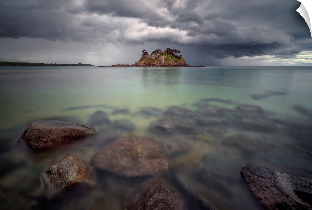 Long time exposure of the shorecoast of Ile du Guesclin island and castle in Brittany, a view at high tide with rocks at f...