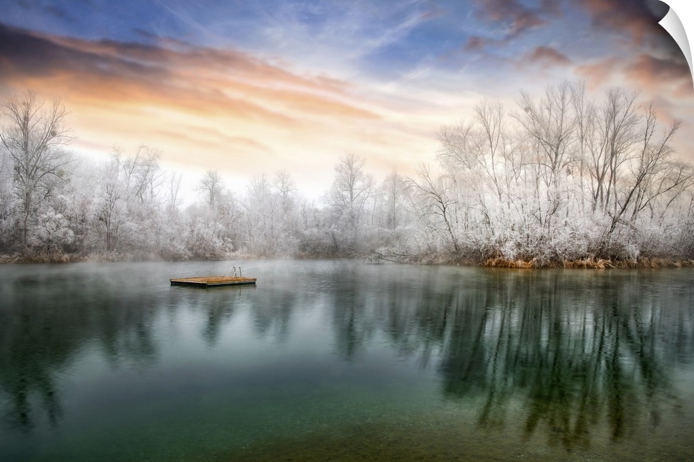 Photograph of a cold sunset across from a lake lined with frozen trees.