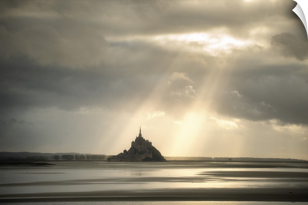 Mont saint michel in normandy, France, before sunset! Sun rays passing throw the grey clouds giving a biblic style to the ...