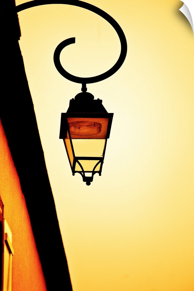 A glowing golden yellow sky with a vintage wrought iron gas lamp.