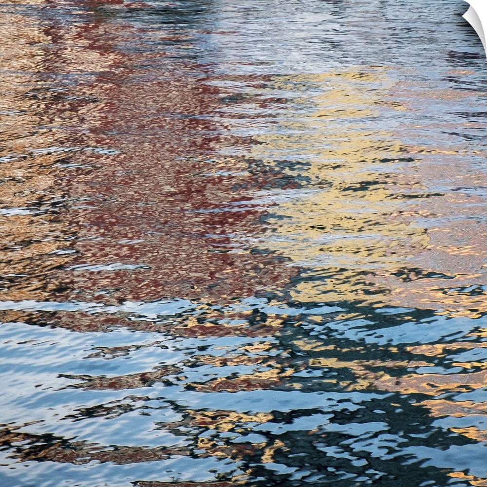 Colorful reflections in rippling water of a pond in the fall.