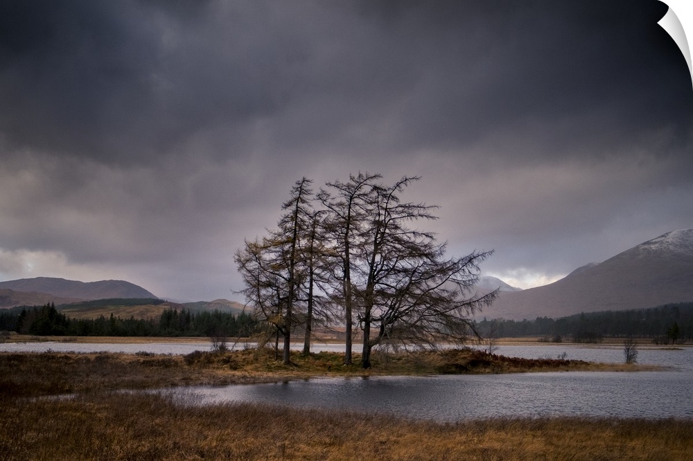 Landscape photograph of Loch Tulla in Scotland with mountains in the background and an overcast sky.