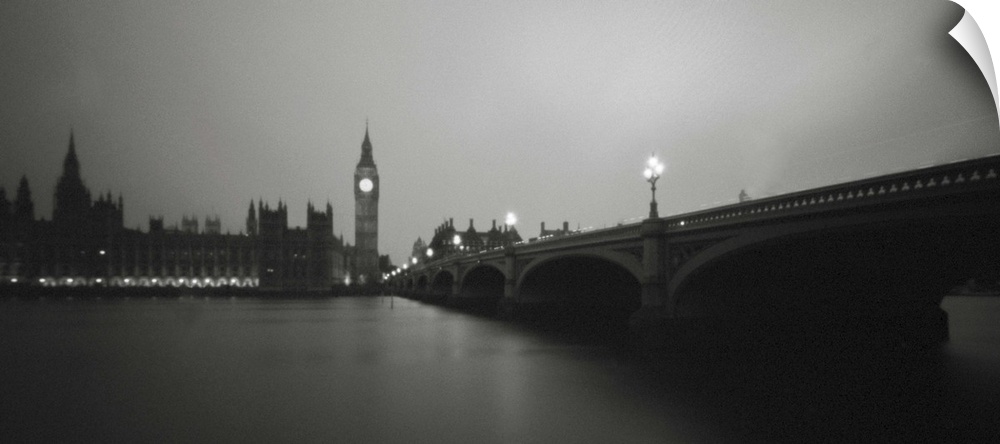 A monochrome black and white sepia toned night time image of the Houses of Parliament, London, England from the River Thames.