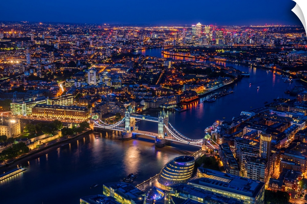 Aerial photograph of Tower Bridge, River Thames, and the city of London lit up at night. View from the Shard building.