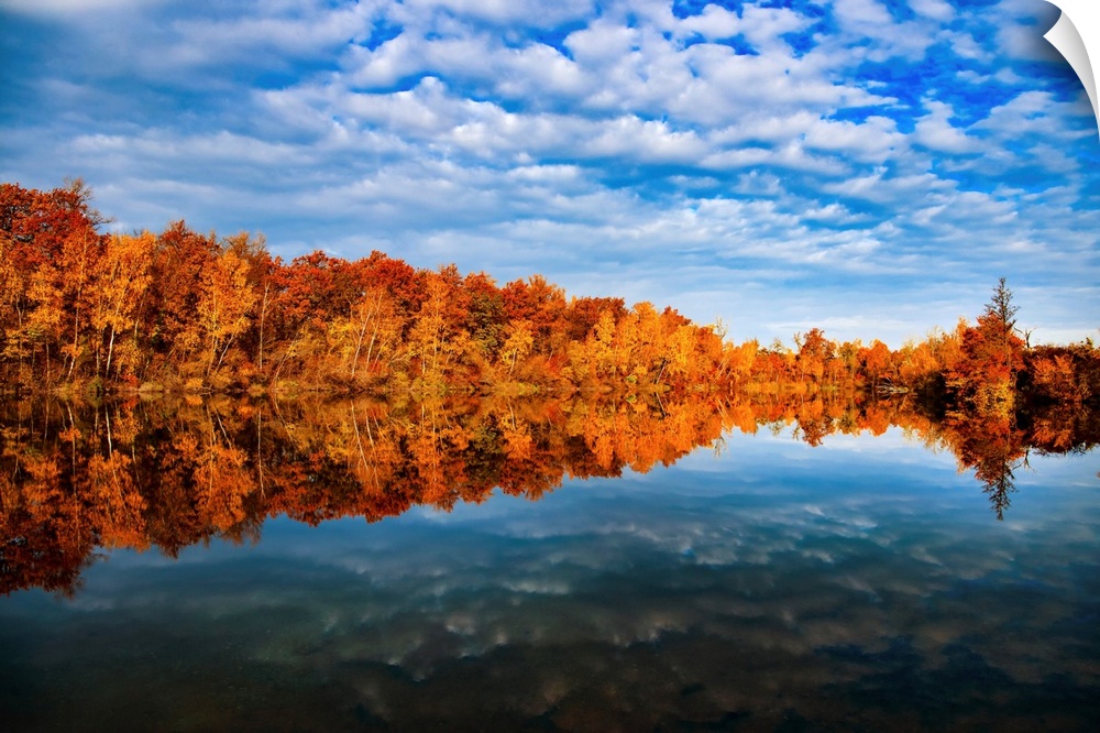 Reflection of autumn trees on a blue lake