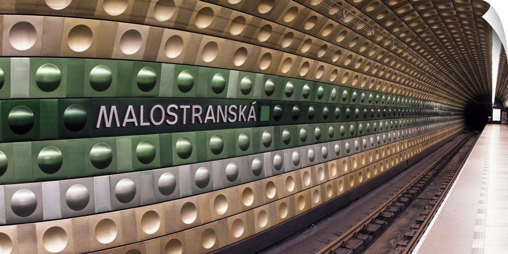 Train tracks at the Malostranska station in Prague, with a geometric pattern in the tiles.