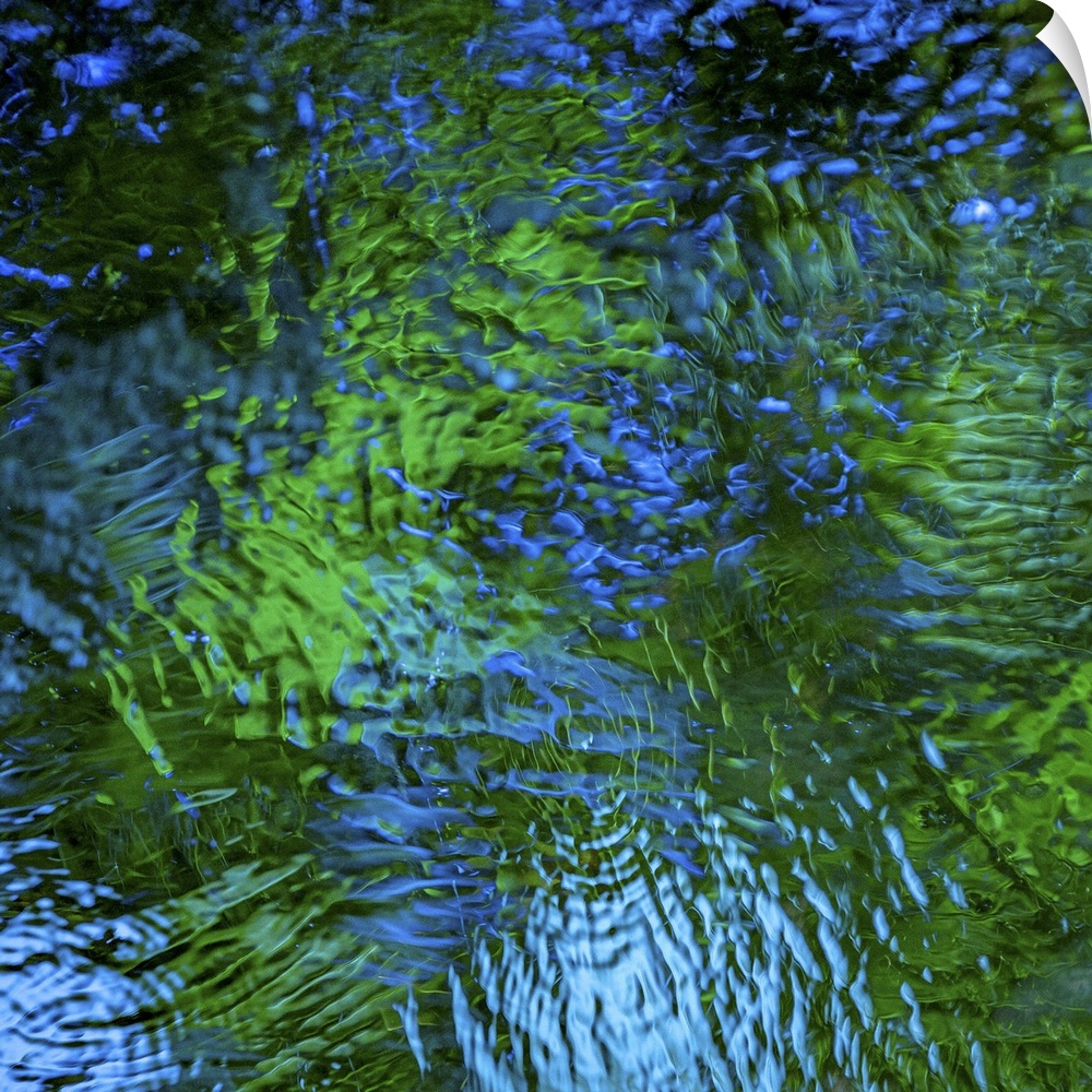Blue and green light reflecting in rippling water.