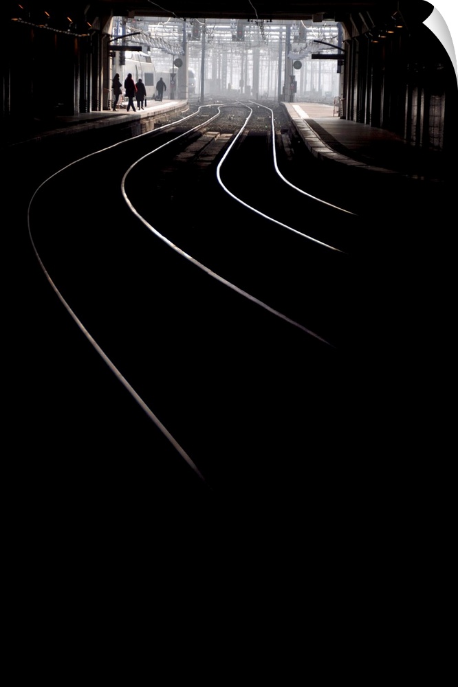 Vertical black and white picture inside Montparnasse Railway station in Paris, France, some lighting tracks.