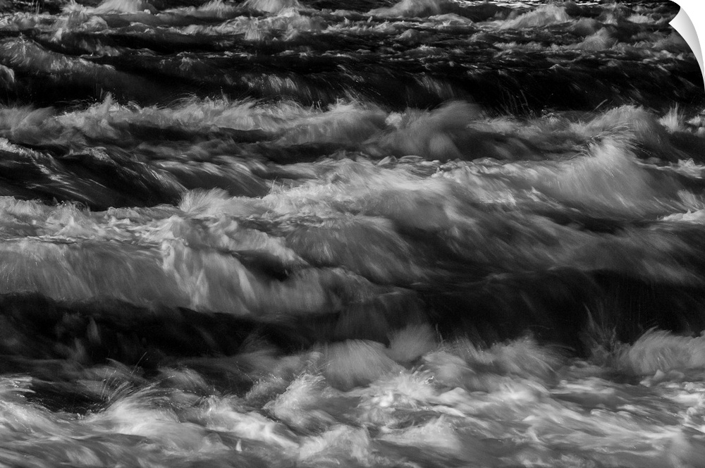 Black and white photograph of water rapids created with a long exposure.