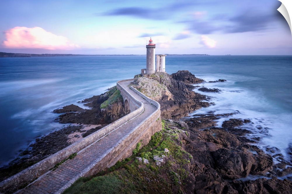 Fine art photo of a lighthouse at the end of a rocky peninsula in France.