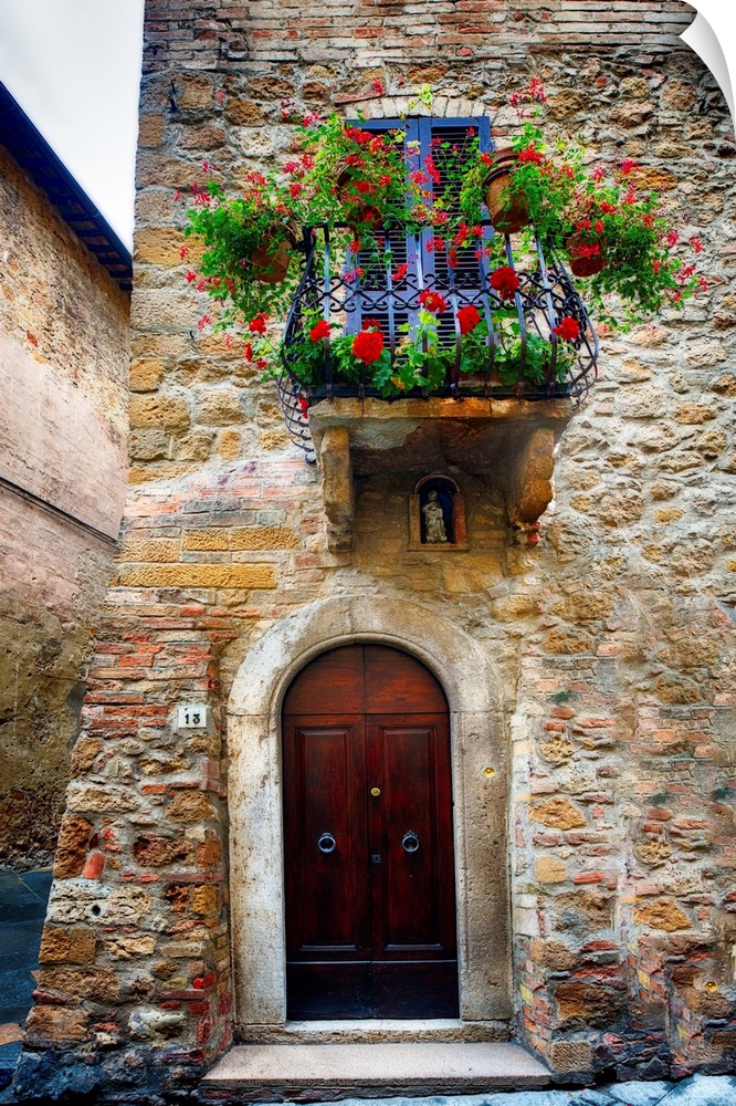 A photograph of the outside of a door and balcony in Italy.