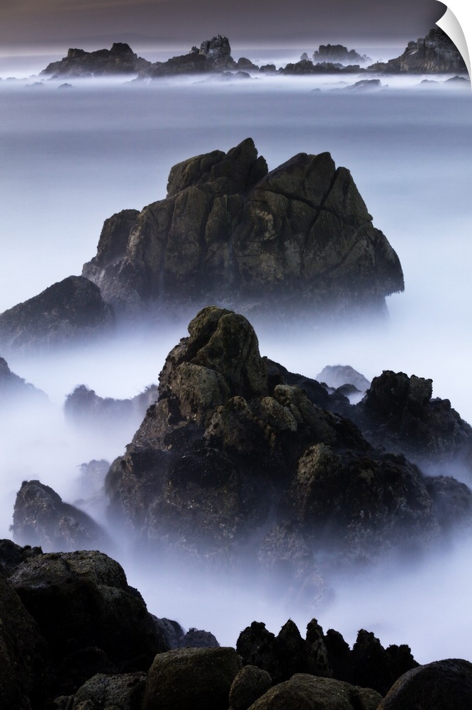 Rocks standing out of the mist over the ocean on the rocky Point Lobos coast in California.
