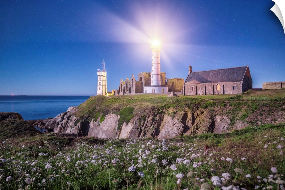 Light shining from the lighthouse on the Bretagne coast in France.