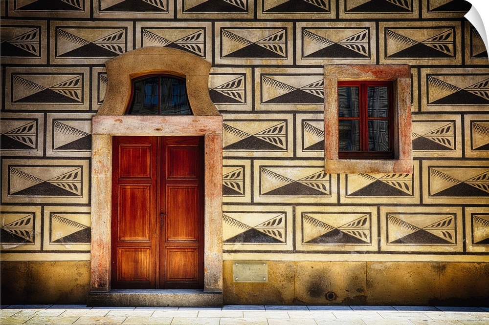 Decorative panels around a window and door on the facade of a building in Prague.