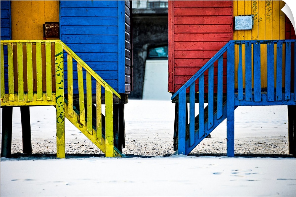 A photo of colorful buildings that have been painted in primary colors over a white snowy landscape.