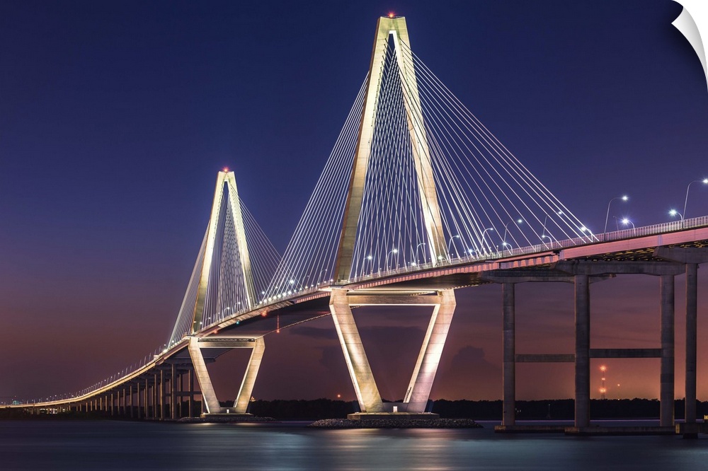 White towers and cables of the Cooper River Bridge in Charleston, South Carolina, at sunset.
