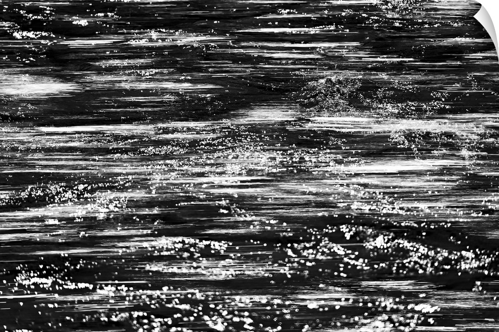Black and white abstract image of rushing water in a river.
