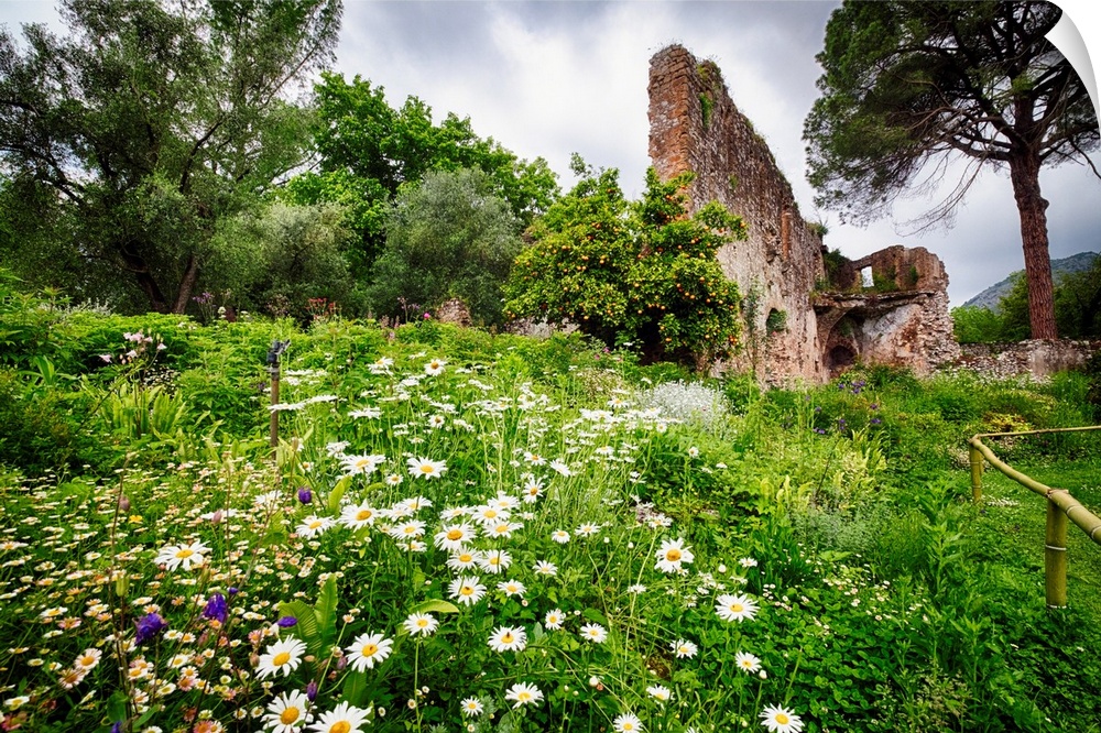 Ruins in a garden with flowers and orange tree, Garden of Ninfa, Cisterna di Latina, Italy.