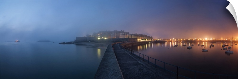 Panoramic view of Saint Malo city in Brittany at night with fog coming from the sea, blue and pink mood.